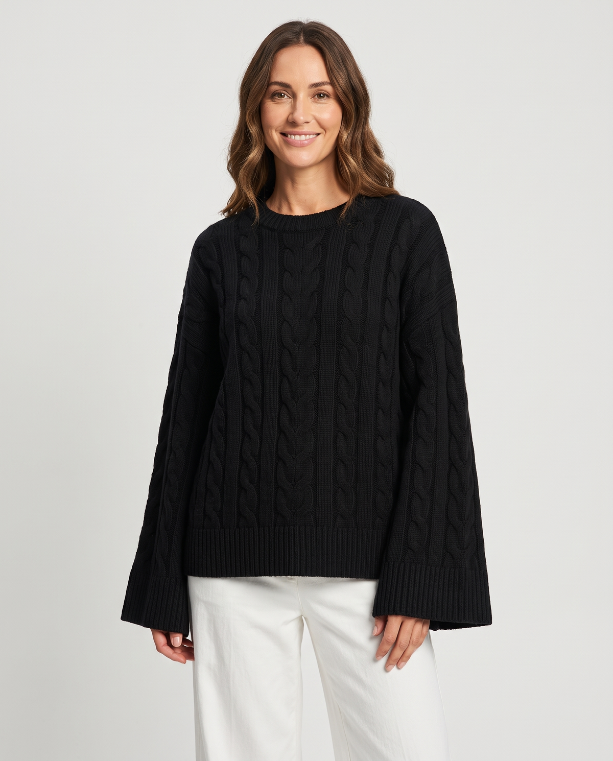 Women's black cable knit sweater with bell sleeves, front view