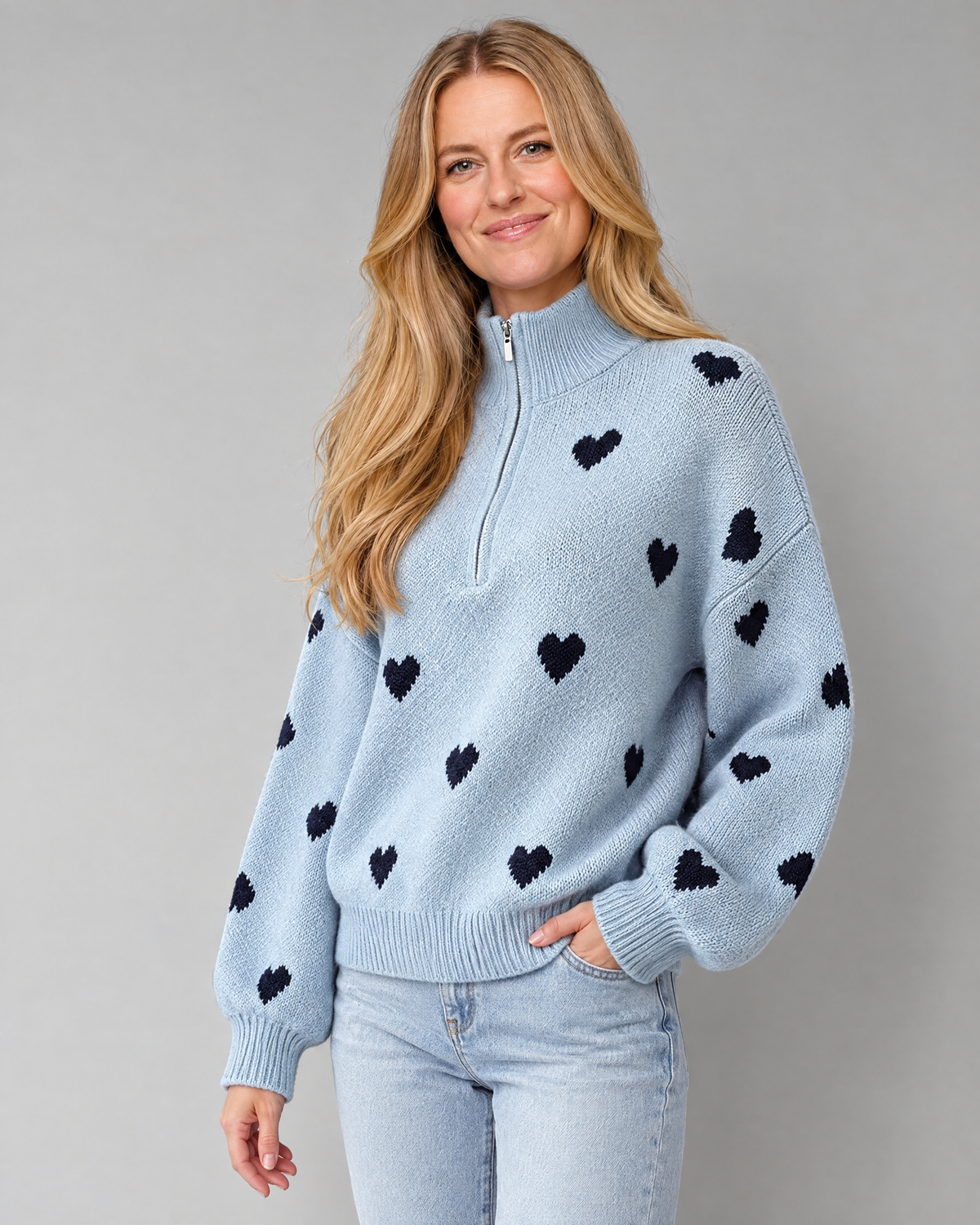 Blonde model wearing high-neck zipper heart jacquard knit sweater