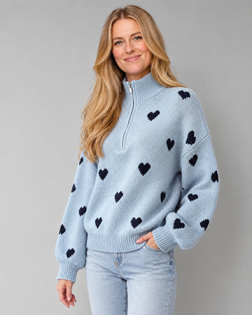 Blonde model wearing high-neck zipper heart jacquard knit sweater